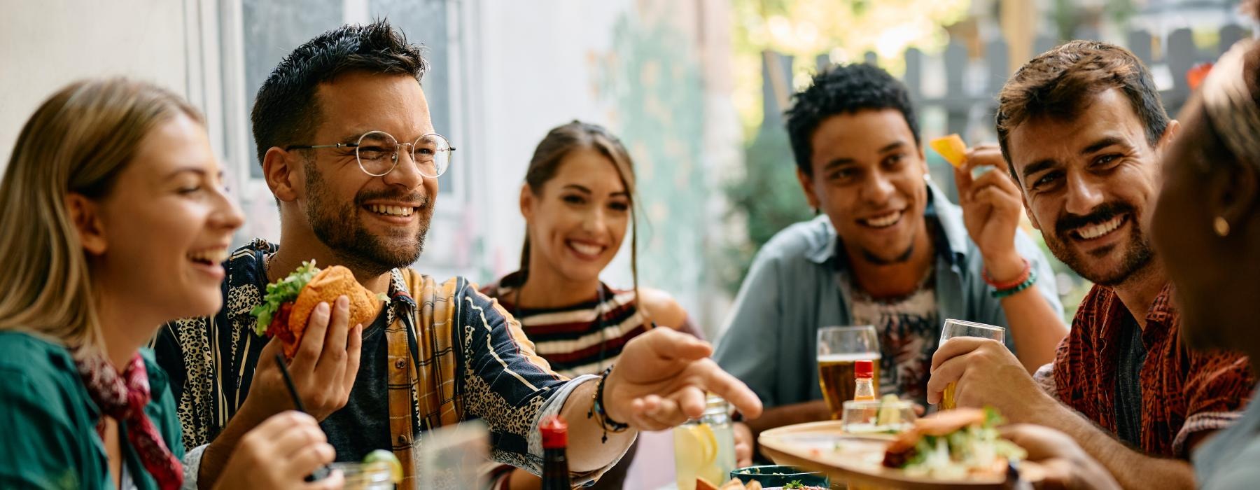 A group of people eating at a table near Sevens apartments by Stanford hospital